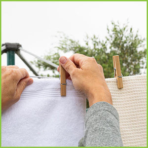 A washing line with towels being hung up dry. The towels are being pegged up using Go Bamboo's clothes pegs.