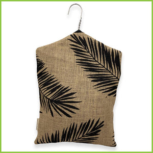A hanging peg bag with a bold black palm leaf pattern. This image is of the rear of the peg bag.