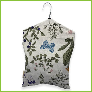 A cotton peg bag with a stainless steel hanger. The peg bag has a wild garden print. This image is of the back of the peg bag.