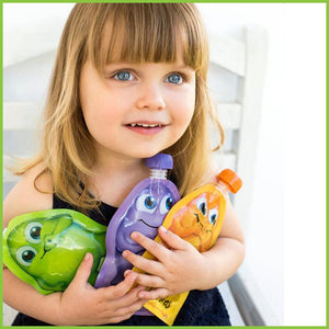 A little girl, aged 2, holding three cute reusable food pouches from Little Mashies.