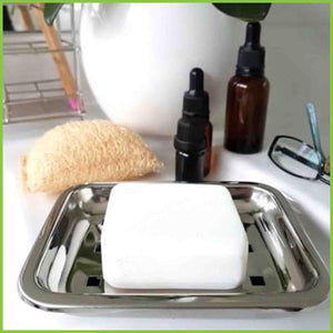 A stainless steel soap dish being used in a bathroom to hold cleansing soap.