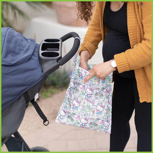 A licensed Hello Kitty wet bag from Bumkins being used by a new mum. The wet bag is hanging from the pushchairs handle and the mum is reaching into it.