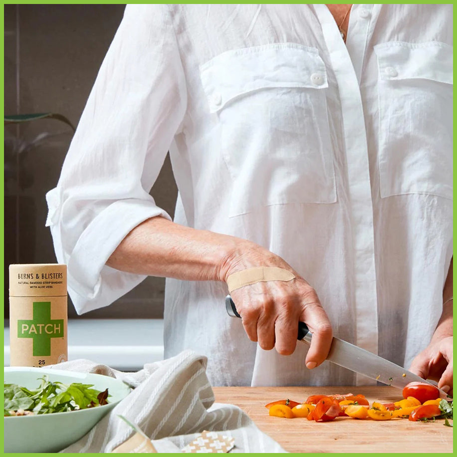 A lady chopping vegetables whilst wearing a bamboo plaster on the back of her hand.