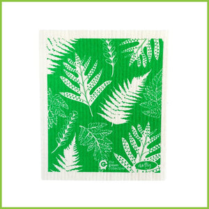 A Spruce Swedish dish cloth with the Fern design by 'Natty.' The cloth is green with white fern leaves all over it.
