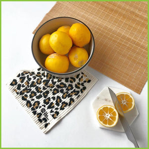 A spruce dish cloth on a kitchen bench. This is a lifestyle image with a bowl of lemons and a knife.