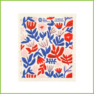 A Spruce Swedish dish cloth with the 'weaving flowers design by 'Fabric Drawer. The dish cloth is white with bold, abstract, red, pink and blue flowers all over it.