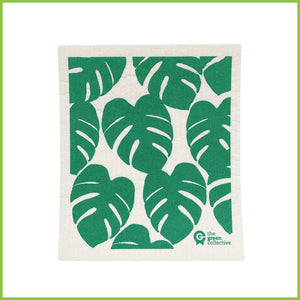 A Spruce Swedish dish cloth with the Monstera design. The cloth is white with large green monstera flowers all of it.