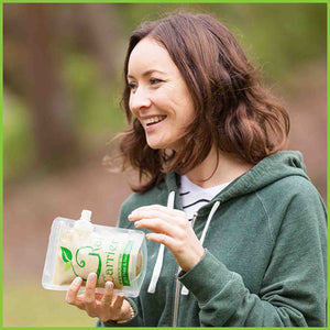 A lady eating from a 300ml Kai Carrier food pouch.