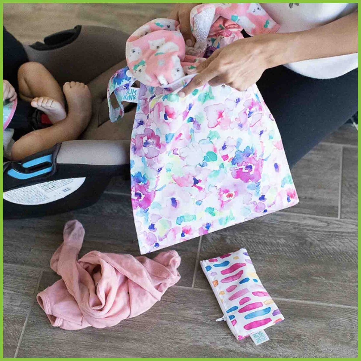 A Bumkins wet bag holding some baby clothes.