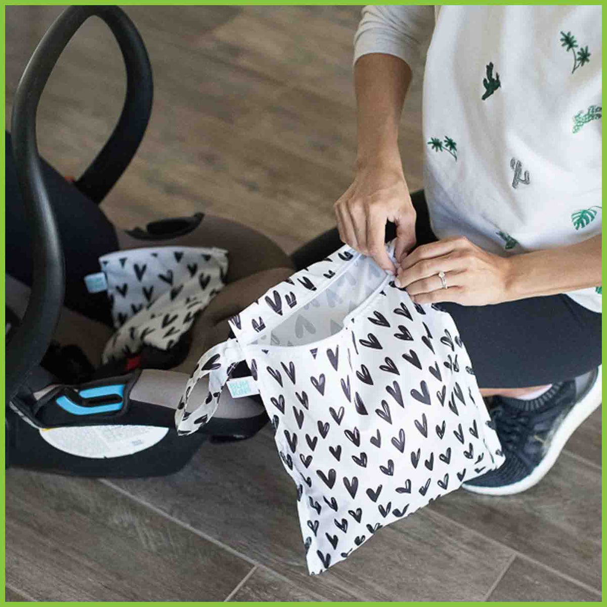 A Bumkins wet bag being zipped closed.