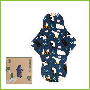 A reusable sanitary pad from Hannah. The image shows a single pad on a white background with its box beside it. The cotton pad is showing you its patterned side. The pattern is a fun dark blue print with lots of cute cats on it, known as 'Cute Cats'.