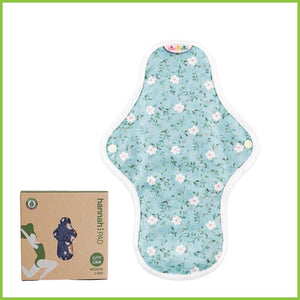 A reusable sanitary pad from Hannah. The image shows a single pad on a white background with its box beside it. The cotton pad is showing you its patterned side. The pattern is a delicate and pretty blue floral pattern known as 'Edelweiss Blue'.