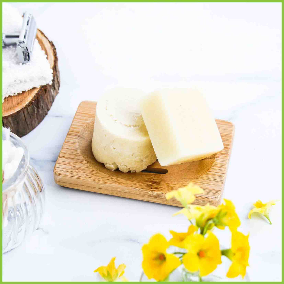 A wooden soap dish with two soap bars sitting on it.