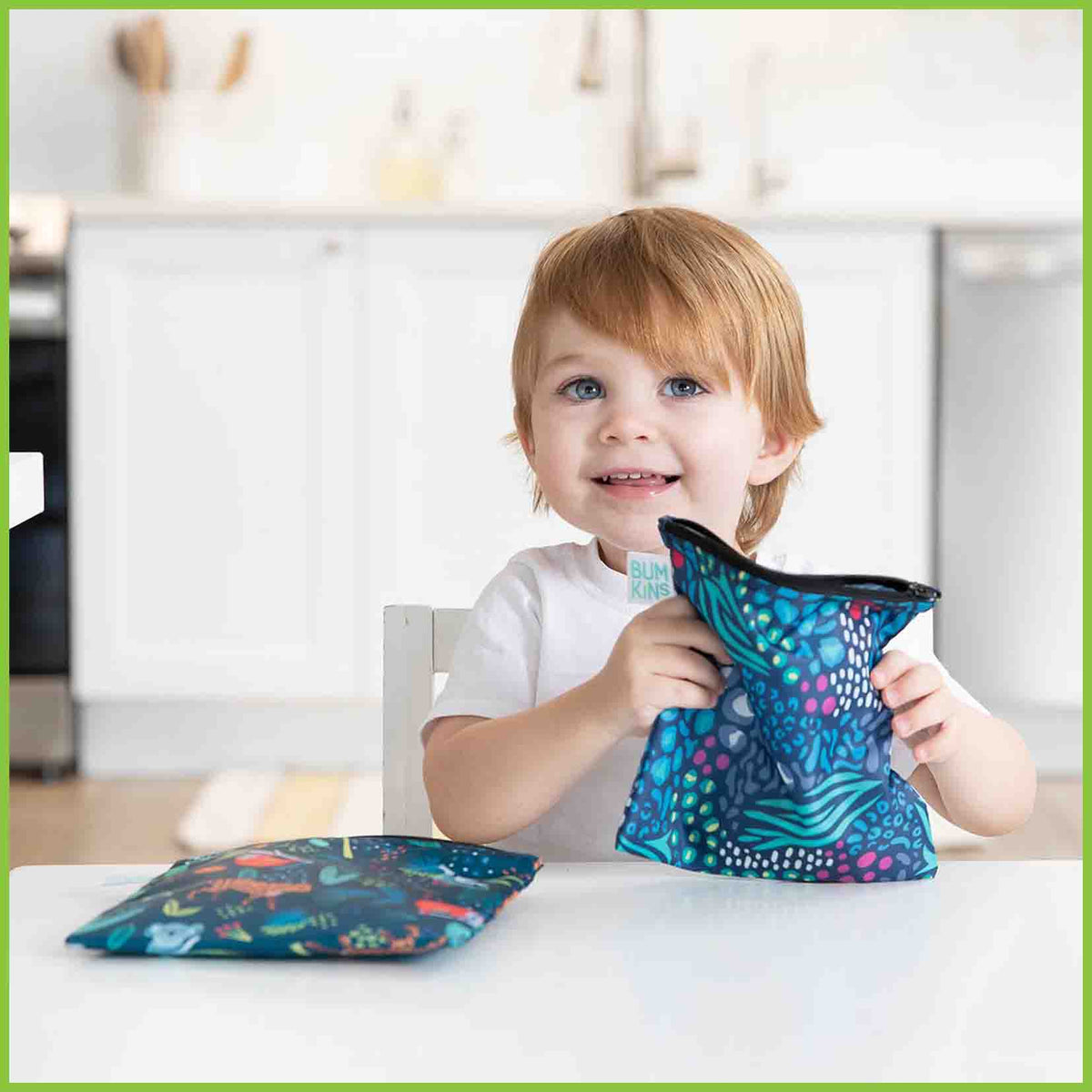 Two Bumkins large snack/sandwich bags in the jungle animals designs, with one bag being held up by a young child.