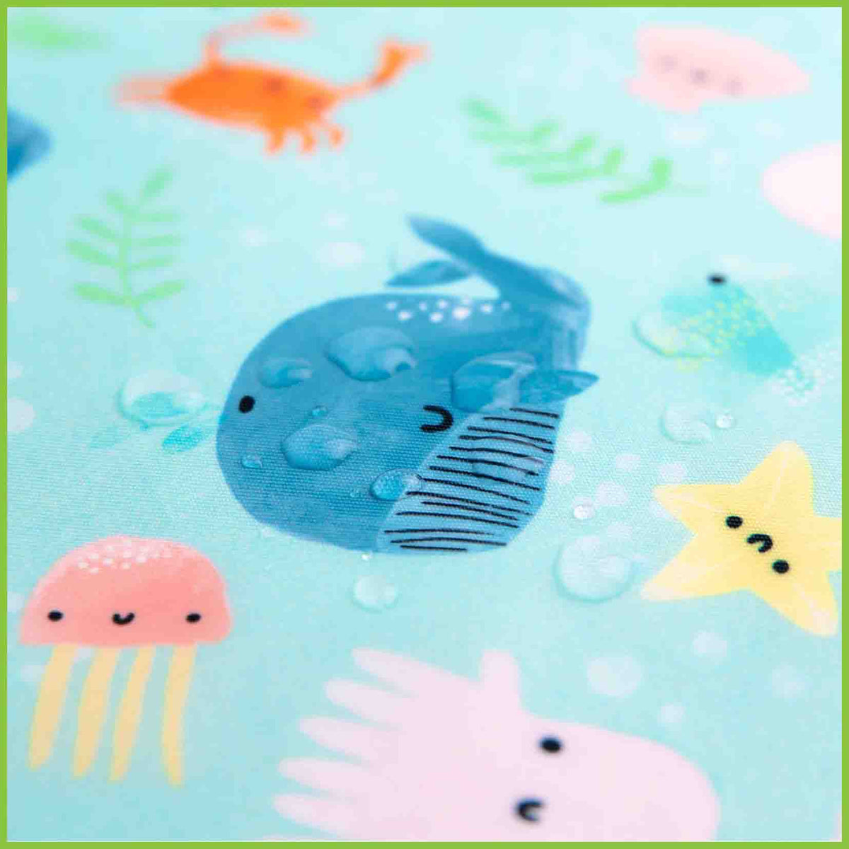 A close up photograph of a Bumkins large snack/sandwich bag showing water droplets sitting on the surface to demonstrate it's waterproofing.