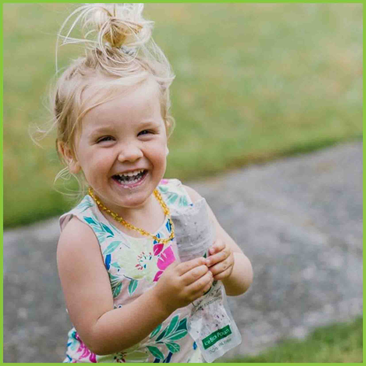 A little girl eating from a Kai Carrier ice block pouch.