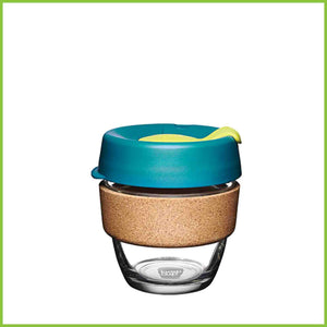 A small KeepCup cork reusable cup with a blue lid and a cork band.