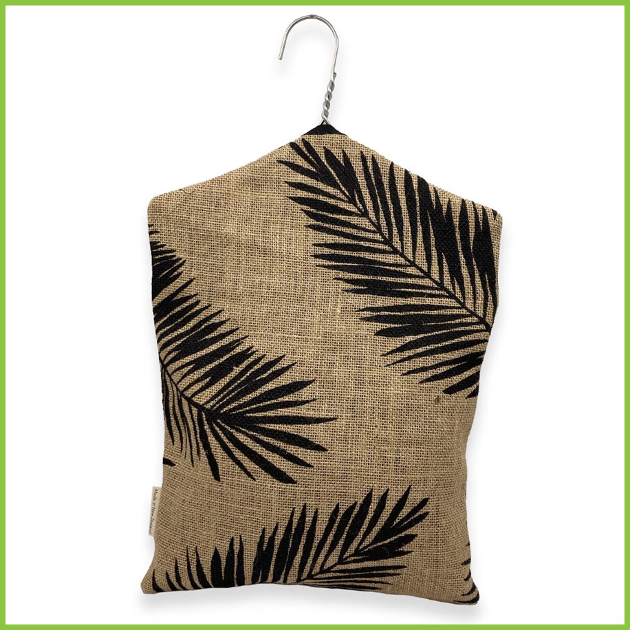 A hanging peg bag with a bold black palm leaf pattern. This image is of the rear of the peg bag.