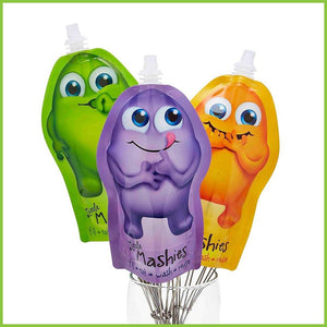 Three Little Mashies reusable baby food pouches. One cute purple monster pouch with its tongue licking, one cute green monster pouch sucking its thumb and one cute orange monster holding its hands up to its mouth..