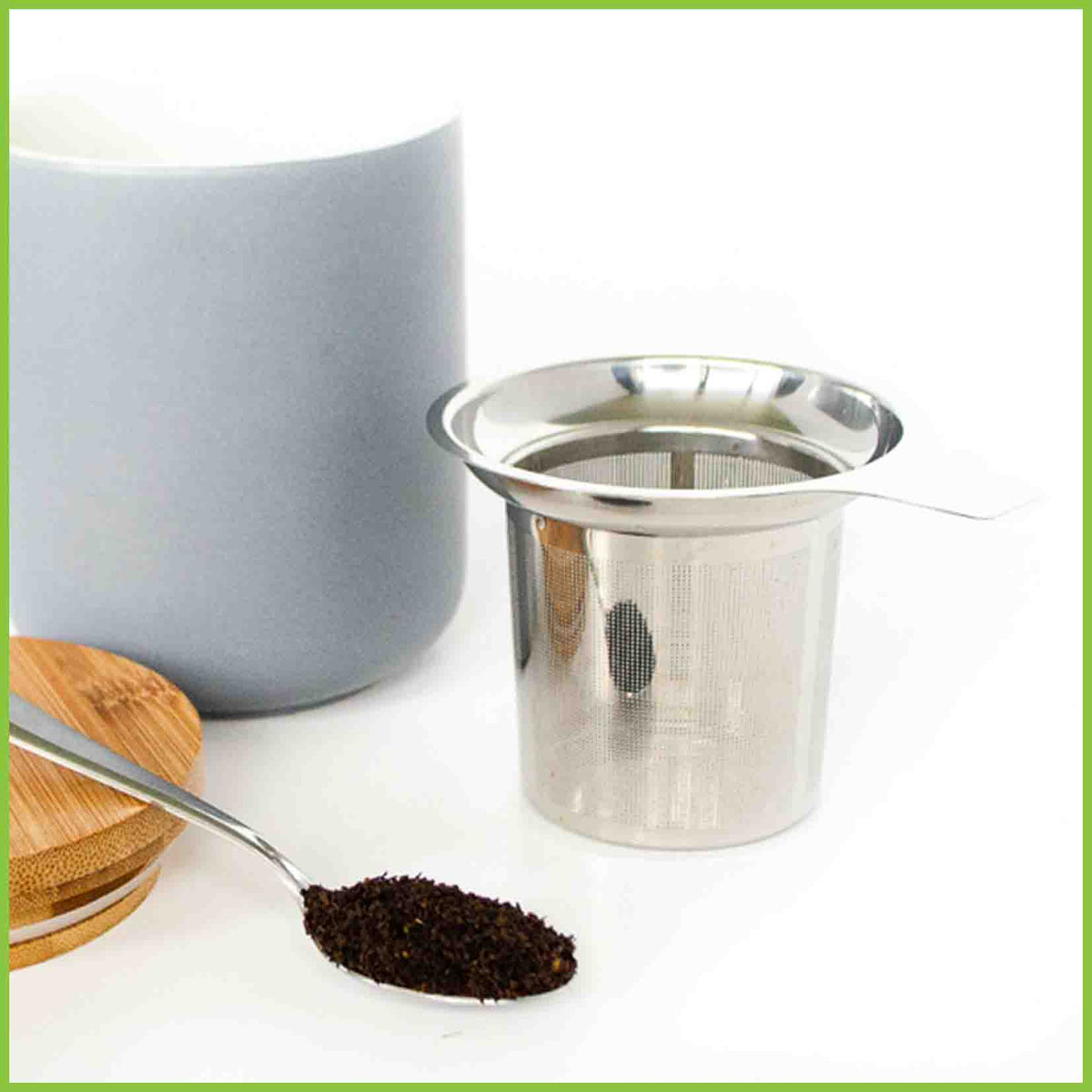 Stainless steel tea infuser with a teaspoon of loose tea leaves.
