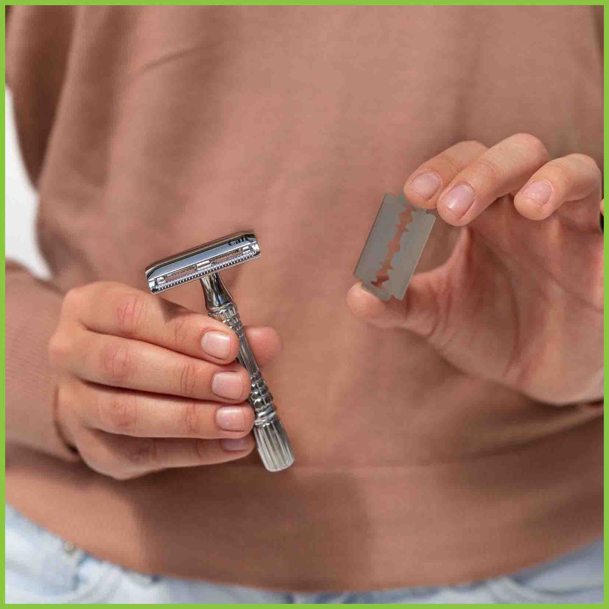 A safety razor and a single blade being held up to the camera.