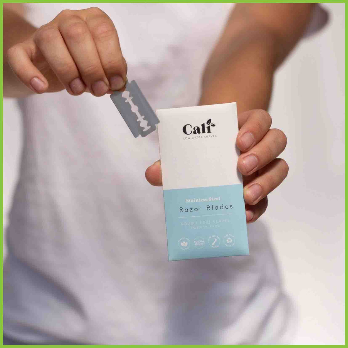 A pack of 20 razor blades and a single blade being held up to the camera.