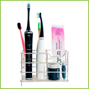 A stainless steel toothbrush holder with electric toothbrushes, toothpaste and floss standing in it.