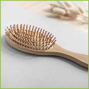 Bamboo and natural rubber hair brush lay on a table.