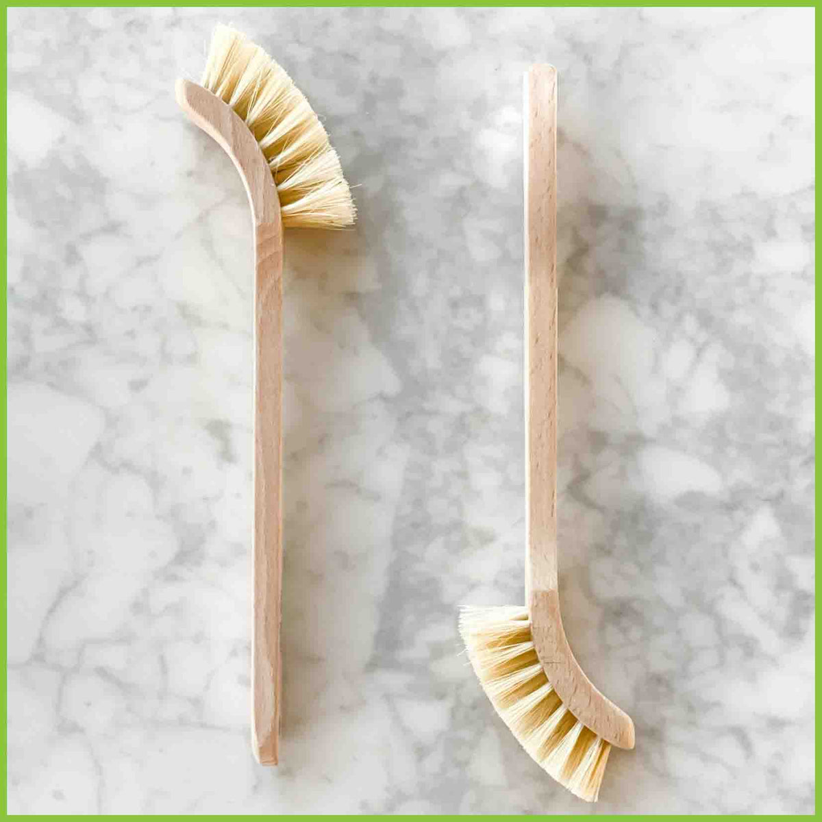 Two wooden dish brushes from The Good Change Store NZ with a photo showing them lying on a bench top.
