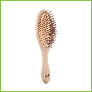 Bamboo and natural rubber hair brush, side facing on a white background.